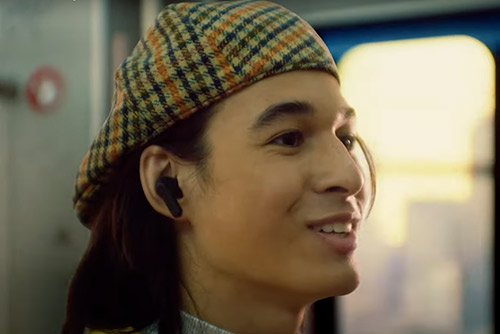 Homme avec écouteurs JBL Wave Buds noirs dans les transports, écoute sans fil pratique