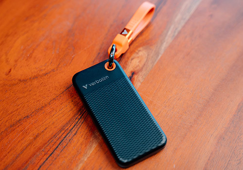 Vue produit du SSD Verbatim avec finition texturée, dragonne orange et port USB-C visible