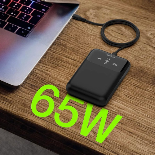 Batterie externe Belkin 65W rechargeant un MacBook via USB-C sur un bureau en bois
