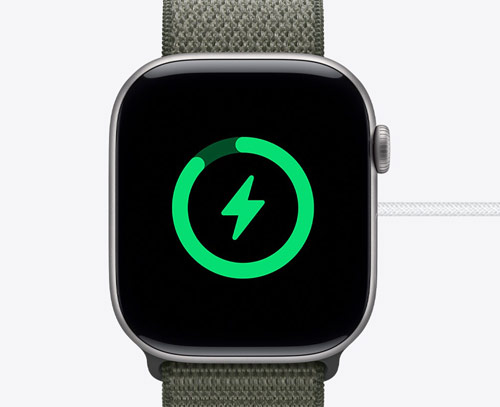 Apple Watch Series 11 en cours de recharge, affichant l'icône de batterie verte sur un écran noir