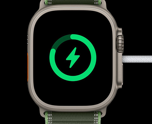 Apple Watch Ultra 3 en charge, affichant l'icône de batterie verte sur fond noir
