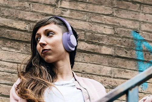 Jeune femme portant casque JBL Tune 520BT violet en extérieur, écoute sans fil confortable