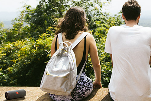 Enceinte Bluetooth JBL Flip Essential 2 noire posée à côté d'un couple en sortie nature.