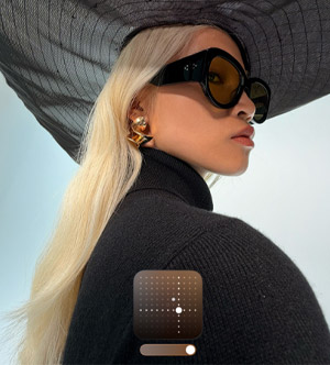 Portrait mode capturé avec l'iPhone 17 Pro, d'une femme blonde portant lunettes et chapeau noir avec ajustement du style photo à l'écran