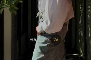 Photo prise avec l'iPhone 17 en mode 2x montrant une personne en jean et chemise blanche