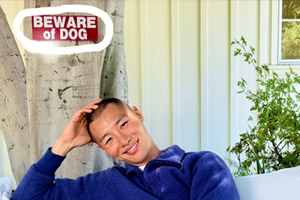Portrait pris avec l'iPhone 17 affichant un homme souriant devant un panneau Beware of Dog