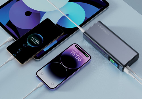Batterie externe 20 000 mAh en train de recharger simultanément une tablette et deux smartphones