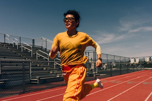 Coureuse sur piste d'athlétisme avec Apple Watch Series 12, app Exercice en cours