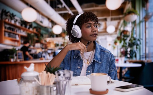 Casque JBL Live 780NC blanc porté dans un café