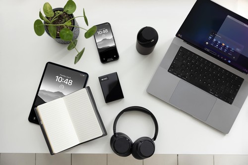 Disque dur externe Western Digital My Passport posé sur un bureau avec ordinateur portable, casque et smartphone