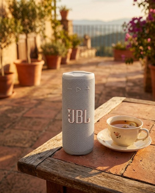 Enceinte JBL Grip Blanche sur terrasse ensoleillée avec tasse de thé