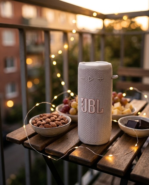 Enceinte JBL Grip Blanche sur balcon avec guirlandes lumineuses