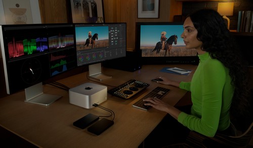 Mac Studio dans une station de postproduction à trois écrans