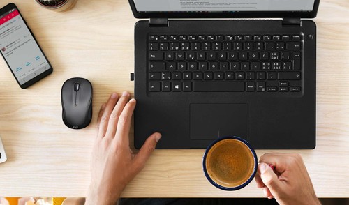 Souris Logitech M325S Graphite utilisée à côté d'un ordinateur portable