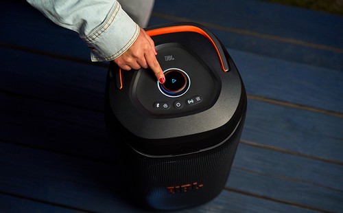 Contrôle du son JBL PartyBox 130, doigt sur le bouton circulaire