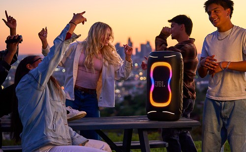 Enceinte JBL PartyBox 130 lors d'une soirée en extérieur au coucher du soleil